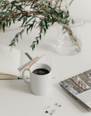 coffee planner plant newspaper on desk